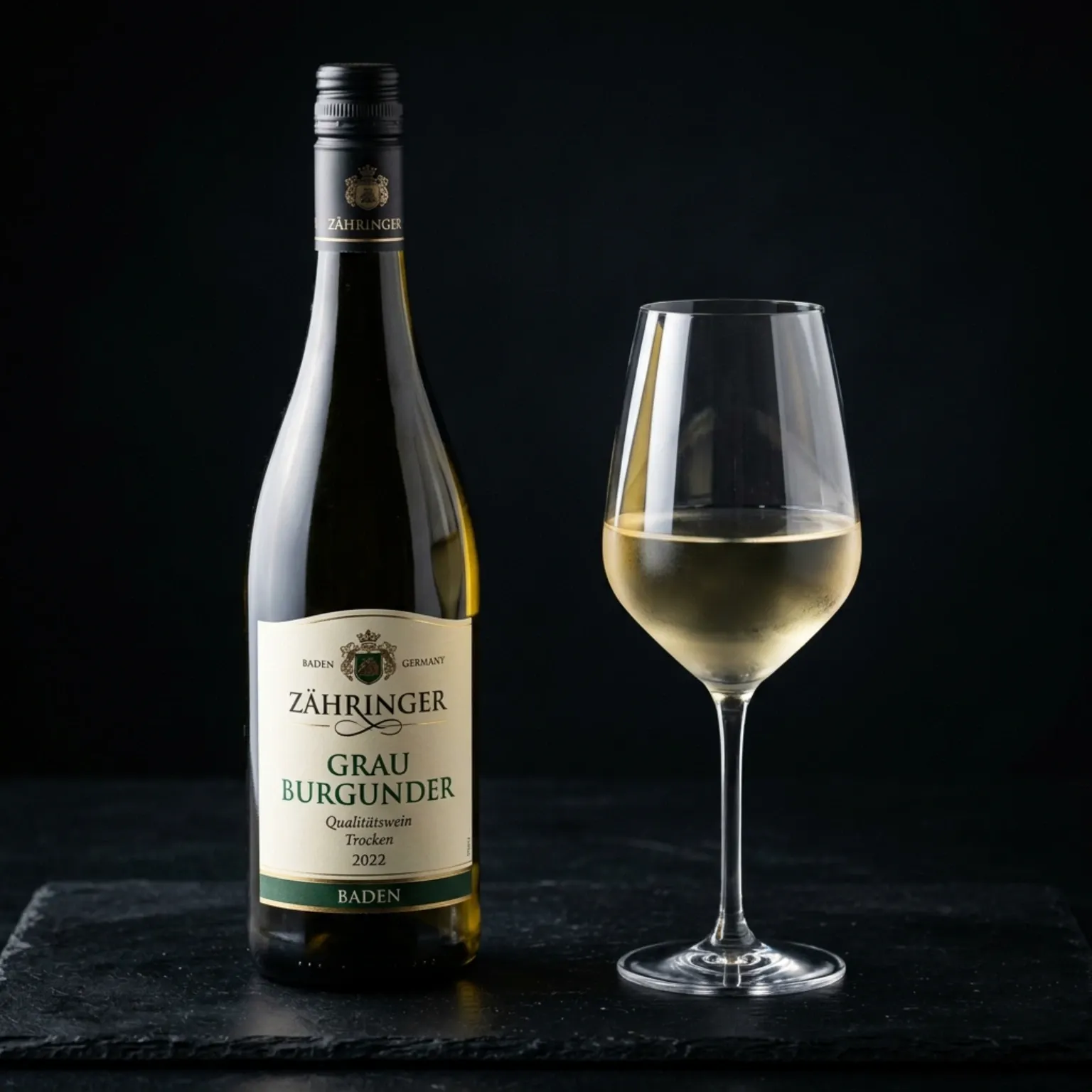 A professional beverage photograph of a bottle of Zähringer Grau Burgunder (Grauburgunder) from Baden, Germany, alongside a filled white wine glass