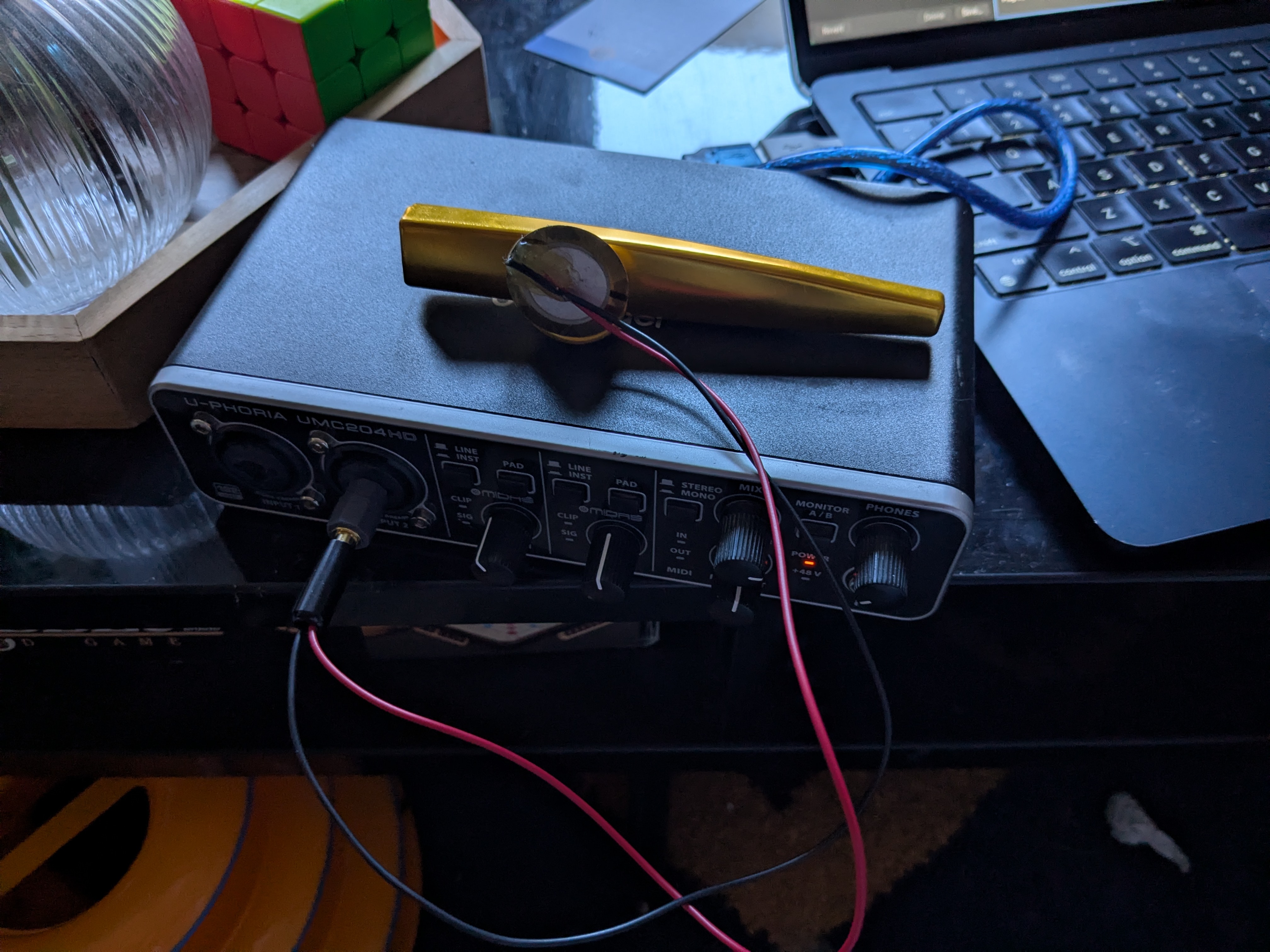 a golden kazoo with a piezo over its horn. a wire leads from the piezo into an audio interface